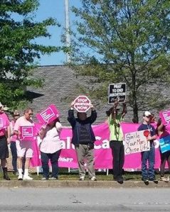 Reformation Presbyterian Church elder holding a sign in the midst of the abortion workers.